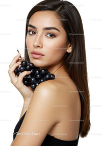 Elegant Woman with Long Brown Hair and Black Grapes Close-Up