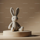 Soft plush bunny toy sitting on beige pedestal