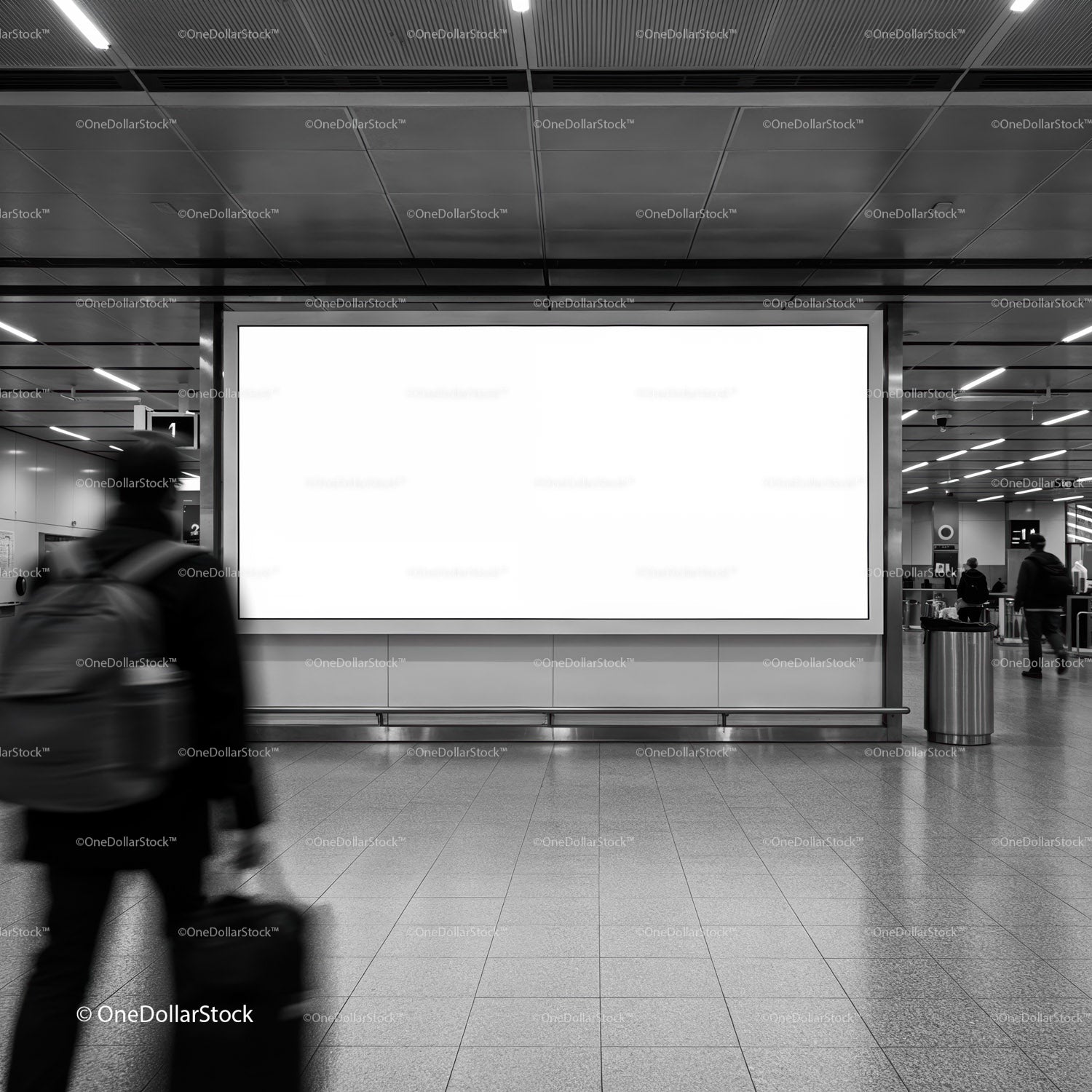 Traveler walking past blank billboard in modern station