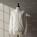 Minimalist white jacket on mannequin with soft lighting