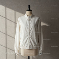 Minimalist white jacket on mannequin with soft lighting