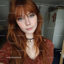 Young Woman with Red Hair and Blue Eyes in Cozy Indoor Setting