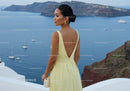 Elegant woman in yellow dress overlooking calm seascape