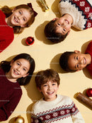 Smiling children in festive sweaters lying on floor