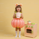 Little girl in balloon skirt holding giant teacup
