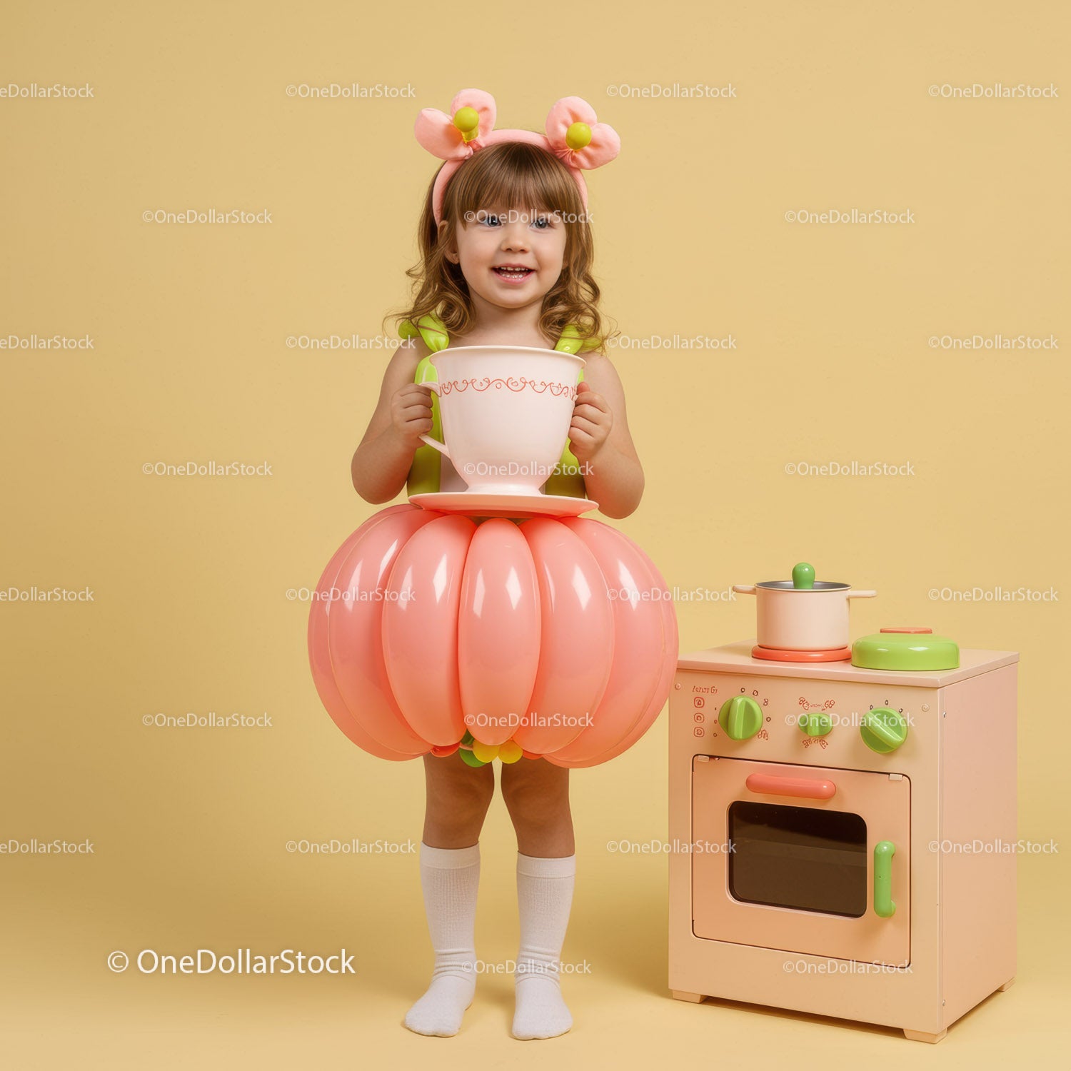 Little girl in balloon skirt holding giant teacup