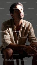 Thoughtful man sitting in low light looking upward