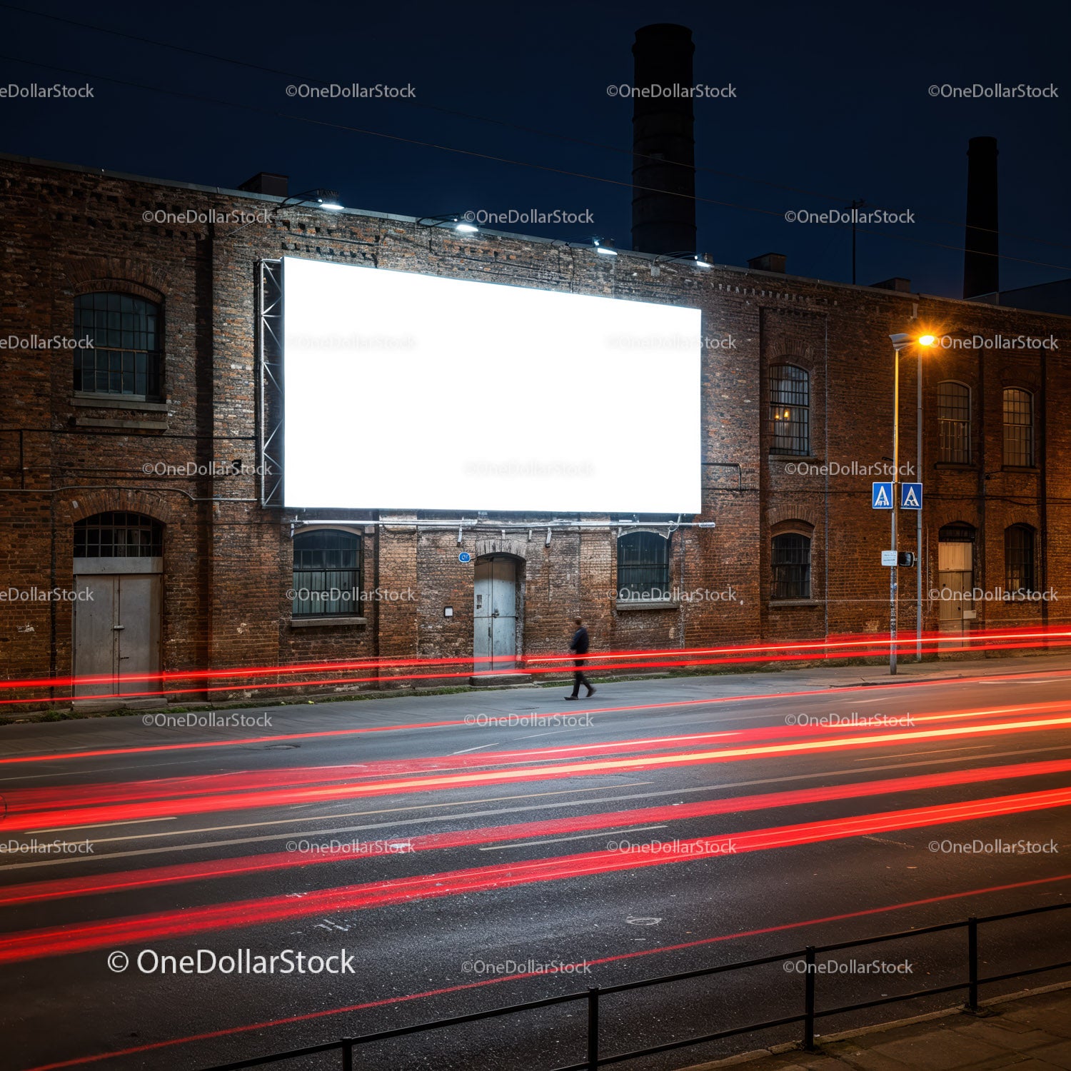 Mężczyzna idący nocą obok oświetlonego billboardu na miejskiej ulicy