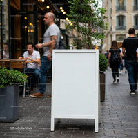 Blank white street chalkboard sign on busy city sidewalk