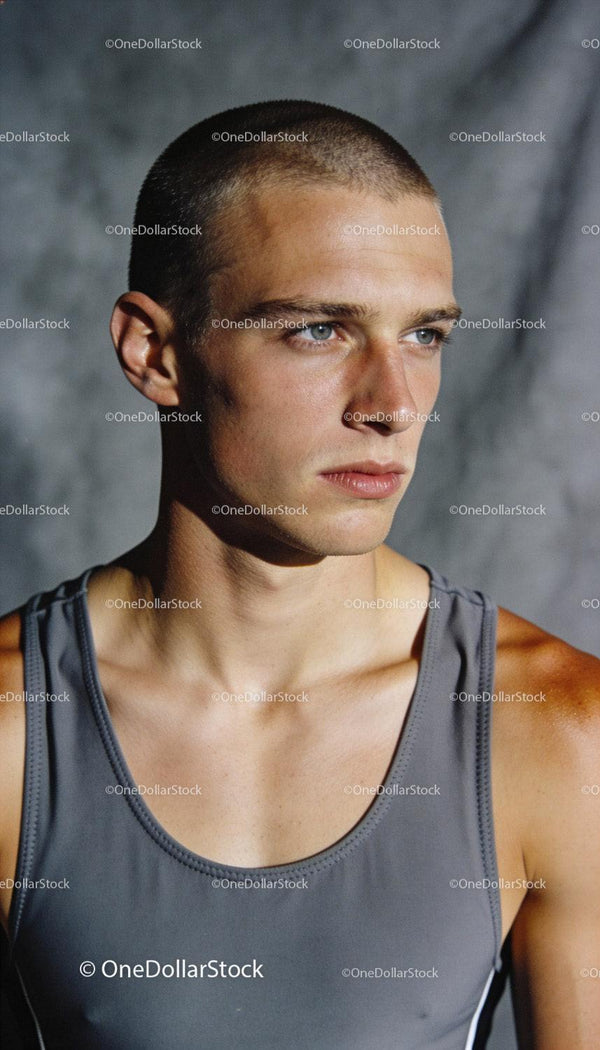 Focused young male athlete in tank top training