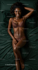 Confident woman relaxing on bed in brown lingerie set