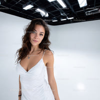 Young Woman in White Dress Posing in Bright Studio with Modern Lighting