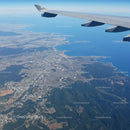 Aerial View of Coastal City with Airplane Wing and Scenic Landscape