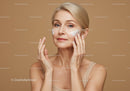 Elegant Mature Woman Applying Facial Moisturizer on Cheek