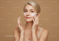 Elegant Mature Woman Applying Facial Moisturizer on Cheek