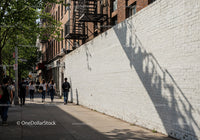 City Sidewalk with Pedestrians and Tree Shadows